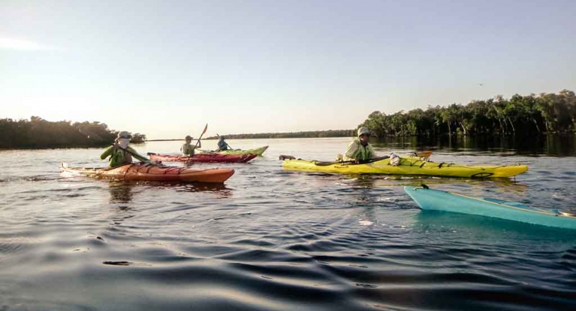 people in kayaks paddle on calm water on an outward bound course in florida